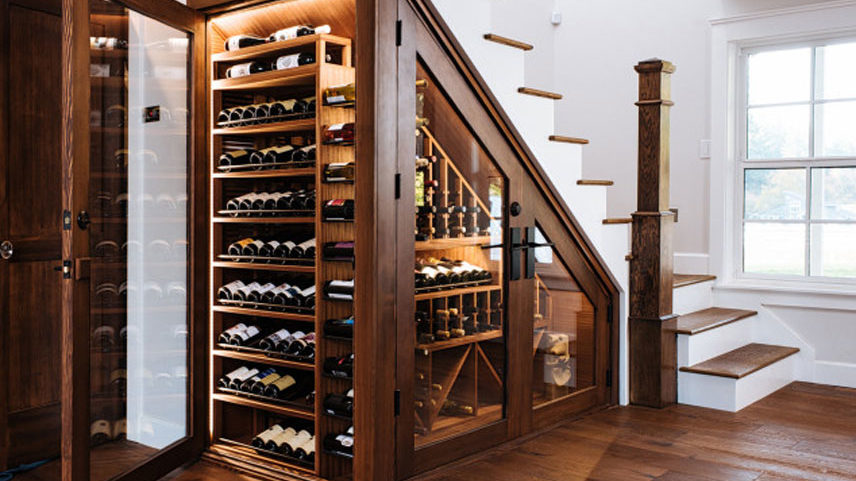 Cellier à vin en bois installé sous un escalier